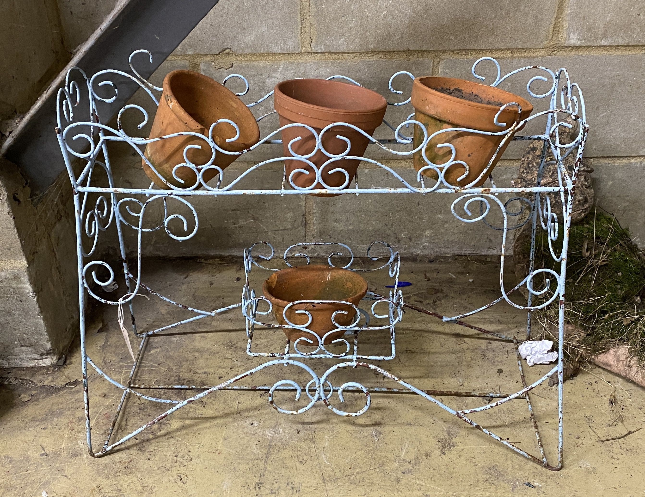 A painted wirework pot stand, width 68cm, together with four terracotta pots